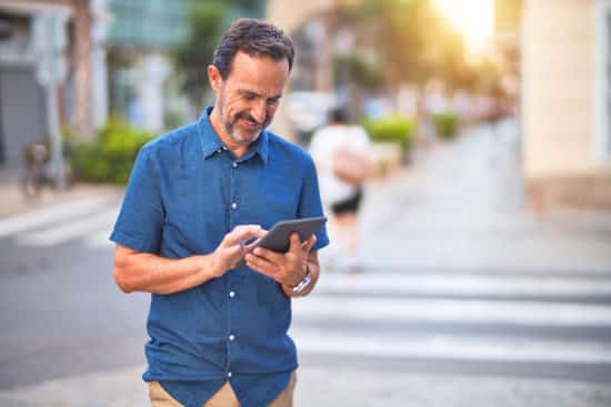 smiling man checking email on tablet