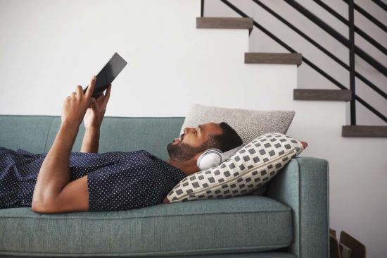 Man On Sofa Watching Movie On Digital Tablet